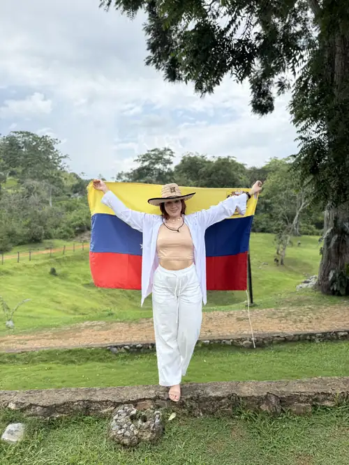 Ángeles Pereira sosteniendo la bandera de Venezuela en el campo